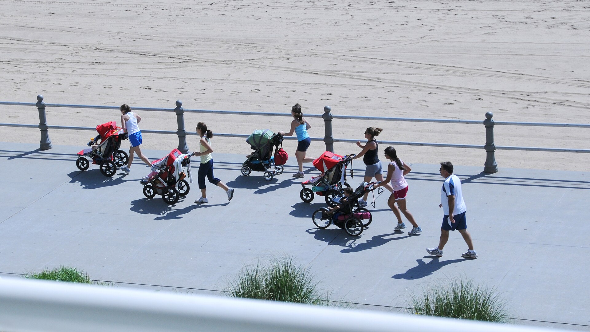 Group of mothers running with jogging pushchairs